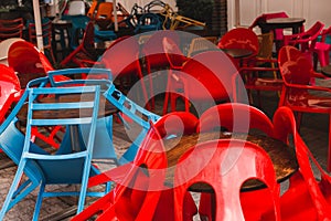 Closed cafe with chairs stacked on top of tables. Colourful tables and chairs in a cafe.