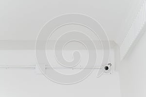 Closed-circuit camera on white ceiling room