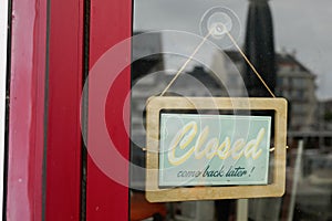 Closed come back later boutique text sign board wood on windows shop restaurant cafe store signboard