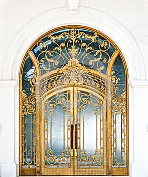 Closed door of building with gold ornate pattern.