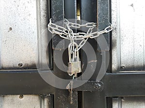 The closed door fence is locked using a chain and then padlocked