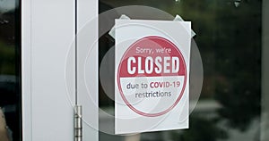 Closed due to Covid sign. Business owner places sign on storefront