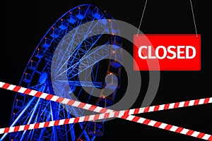 Closed due to a pandemic. Passage to ferris wheel is blocked by red and white ribbon and sign hanging is closed.