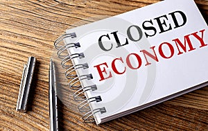 CLOSED ECONOMY text on notebook on grey background