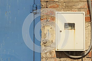 Closed electric meter on the old brick wall of the garage