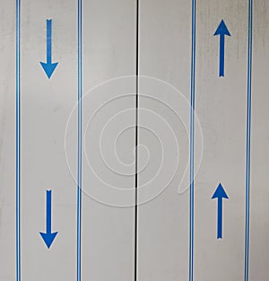 Closed elevator doors with blue up and down arrows.