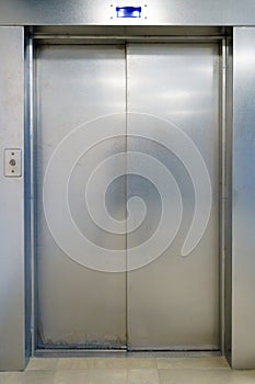 Closed elevator doors. Shiny metal elevator doors in a new modern elevator. An empty hall on the floor of an office building