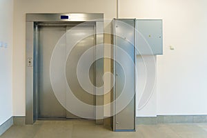 Closed elevator doors. Shiny metal elevator doors in a new modern elevator. An empty hall on the floor of an office building