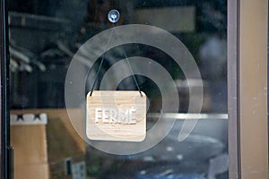 Closed french text means ferme in france language on wall store text sign wooden board on facade shop door