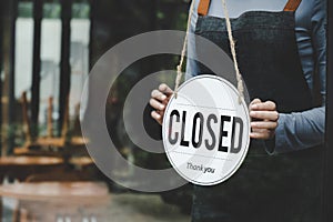 Closed. friendly waitress wearing protection face mask turning open sign board on glass door in modern cafe coffee shop, cafe rest