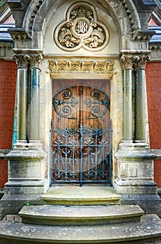 Closed front door of a Christian chapel with Greek columns on the sides of the entrance
