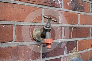 Closed garden tap on brick wall