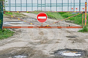 Closed gate of the dirty road.