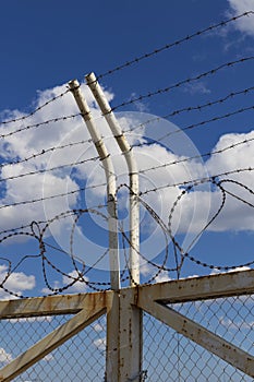 Closed gates and posts with barbed wire and mesh