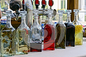 Closed glass bottles with colored drinks on the table
