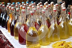 Closed glass bottles with colored drinks on the table. Many small bottles of alcoholic beverages.