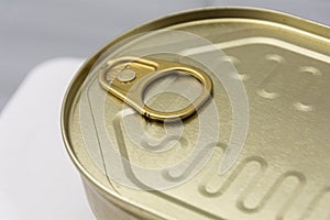 closed golden metal can close-up of a can with a key to open