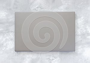Closed gray laptop on marble background. Top view Template