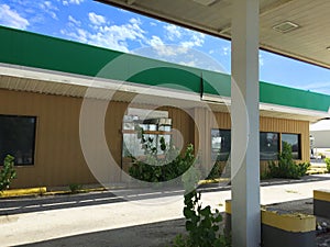 Closed green white and tan gas station 04