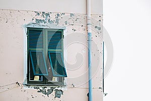 Closed green wooden shutters on a house facade