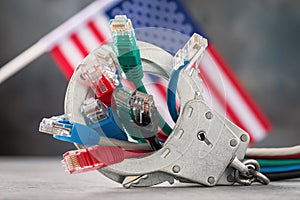 Closed handcuffs on network wires and the USA flag on an abstract background, concept on the theme of punishment for crimes on the