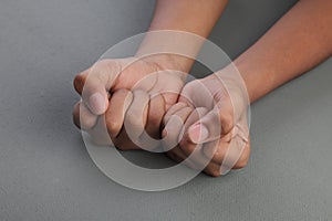 Closed hands on a grey area