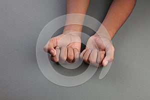 Closed hands on a grey area