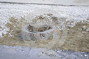 closed hatch, destroyed asphalt, sand and crushed stone left after road repair