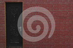 closed iron, metal door in red, brown brick wall. exterior of new, modern house. Steel door in a new brick wall. domestic