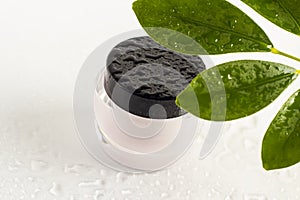 Closed jar of cream. Container with a black lid