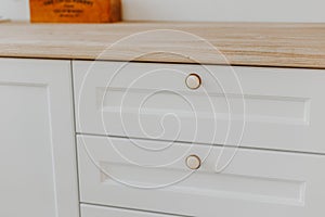 Closed light-colored kitchen drawer with plates inside, a smart solution for storing and organizing the kitchen