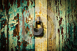 Lock on weathered planks of gates painted in blue