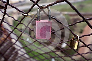 Closed love lock as symbol of eternal love with fence on bridge in city. Padlocks of lovers on bridge as symbol of connection.