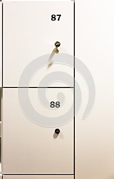 Closed metal lockers in locker room with numbers on front door