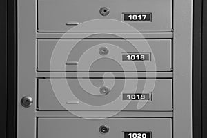 Closed metal mailboxes with keyholes and sequence numbers indoors