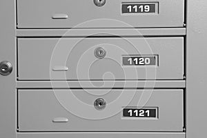 Closed metal mailboxes with keyholes and sequence numbers indoors