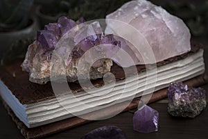 Closed Notebook or Journal with Amethyst and Rose Quartz Crystals on top photo