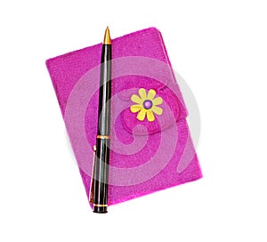 Closed notebook in a purple cover with a black ballpoint pen on