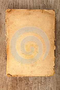Closed old softcover book on a wooden background