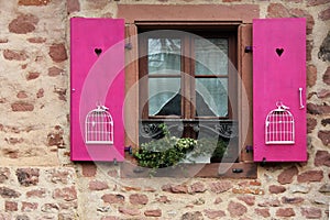 Closed old window with open violet shutters