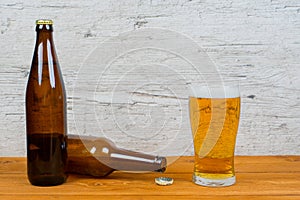 Closed and opened beer bottles with full glass