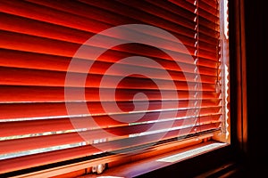 Closed orange plastic blinds with sunlight in the morning. window with blinds. Interior design of living room with