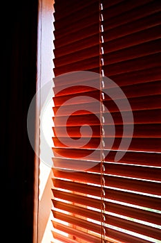 Closed orange plastic blinds with sunlight in the morning. window with blinds. Interior design of living room with