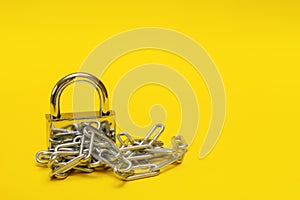 closed padlock with chain on yellow background with copy space, prohibition, taboo