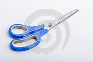 A closed pair of scissors with a blue grip