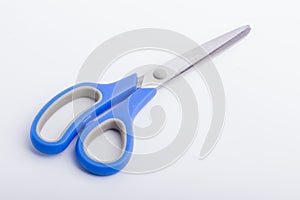 A closed pair of scissors with a blue grip