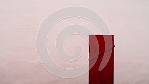 Closed permanently red wood door on pink concrete wall photo