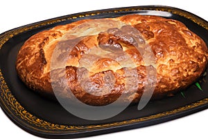 Closed pie with a snapper on a tray isolated on a white background