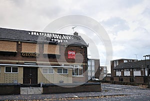 A closed public house stands derelict and boarded on a housing estate in hunslet leeds after being attacked by vandals.