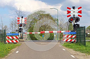 Closed railroad barriers at a rural railway crossing in the polder, Netherlands